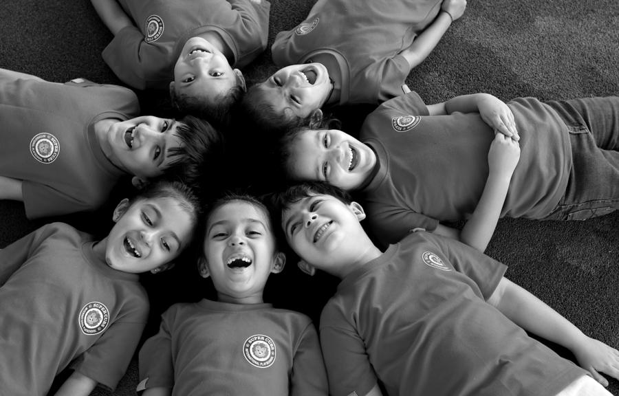 SuperCubs children lying in a circle, laughing