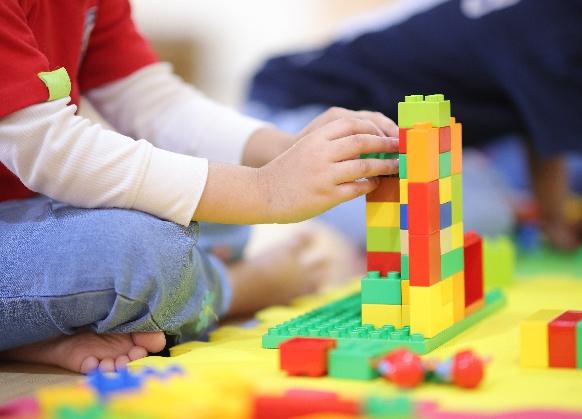 A child building a tower of coloured blocks