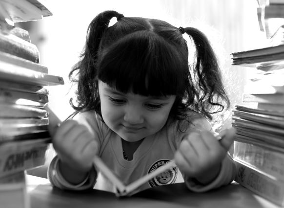 A girl reading between stacks of books